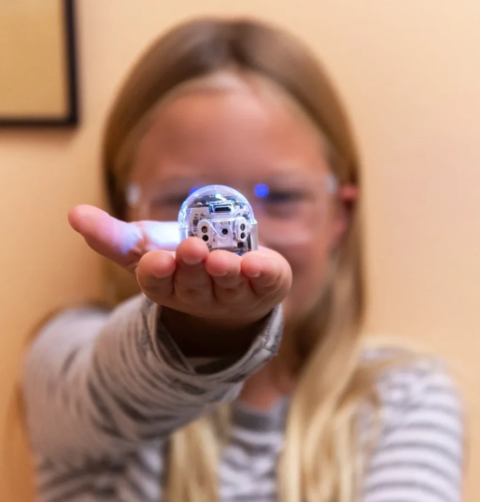Child holding Ozobot Evo in front of them